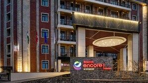 A multi-story hotel with a prominent entrance featuring a modern design and a sign for Ramada Encore by Wyndham. - Ramada Encore By Wyndham Tashkent (Tashkent)
