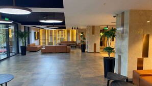 A spacious lobby with modern furnishings, including sofas and a coffee table, and large pendant lights. - Ramada Encore By Wyndham Tashkent (Tashkent)
