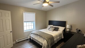 A bedroom with a bed, a ceiling fan, a window with blinds, and a nightstand with a lamp. - Minutes away from Presque Isle. 
On the ATV trail access and SNOWMOBILE Trail (Chapman)