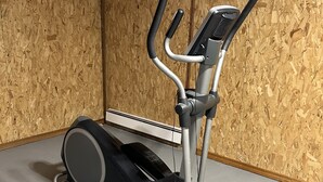 An exercise machine in a room with wooden panel walls and a grey floor. - Minutes away from Presque Isle. 
On the ATV trail access and SNOWMOBILE Trail (Chapman)