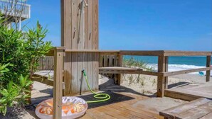 Eine Holzterrasse mit einer Holzkonstruktion, möglicherweise eine Sauna oder Dusche, verbunden mit einem Schlauch.