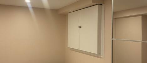 A bedroom with a bed, a wardrobe, and a mirror.