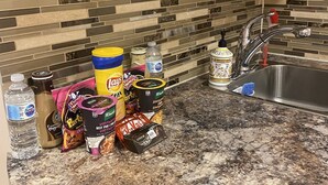 A kitchen with a granite countertop, a tiled backsplash, and various food items and kitchen supplies. - Lovely one bedroom unit  (Mississauga)