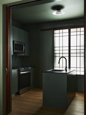 A modern kitchen with a central island, a microwave, and a stove. - Elm Grove Co.Housenhv (Downtown New Haven)