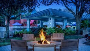 A fire pit with benches, surrounded by a garden and a building with a blue roof. - Marriot's Harbour Lake 
2 Bedroom Villa (Orlando)