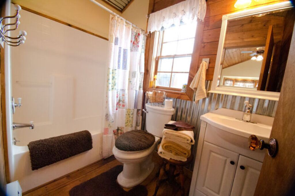 Une salle de bain avec des toilettes, un lavabo et un miroir.
