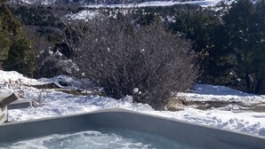 A hot tub with a mountainous landscape in the background. - Sagewood Cabin @ Whispering Oaks, 20 miles from Moab! (Moab)
