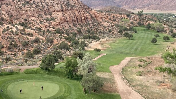 A golf course with a desert landscape and rocky cliffs in the background. - Sagewood Cabin @ Whispering Oaks, 20 miles from Moab! (Moab)
