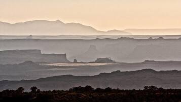 Un paysage côtier caractérisé par des collines en terrasses et une chaîne de montagnes lointaine.