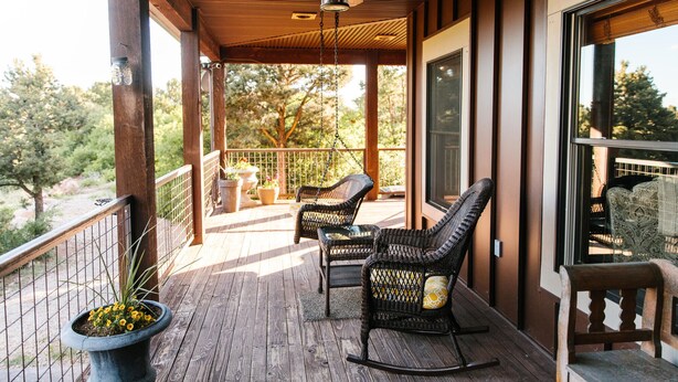 A wooden deck with wicker chairs and a ceiling fan. - Jaydee's Run Cabin @ Whispering Oaks, 20 miles from Moab! (Moab)