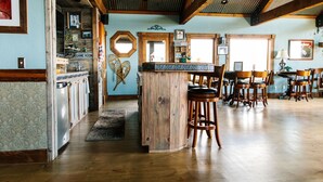 A spacious kitchen with wooden cabinets, a central island with stools, and a dining area with multiple chairs.