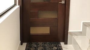 Una puerta de madera moderna con un diseño geométrico y una cerradura digital.