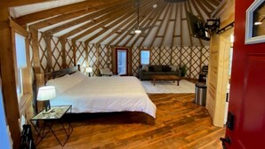 A yurt with a bed, a sofa, and a small table. - Gray Yurt in Hocking (Logan)