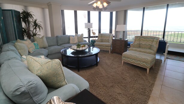 A living room with a sectional sofa, a round coffee table, and two armchairs. - 4 BR Oceanfront Oasis: Luxury Amidst the Bustle w Heated Pool & Private Balcony (South Padre Island)