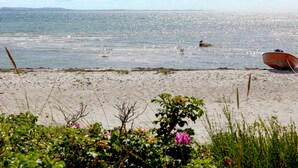 Une plage avec un bateau sur le sable et la mer en arrière-plan.