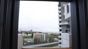Un balcon donnant sur un paysage urbain, avec des bâtiments et une route.