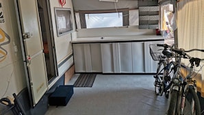 Un espacio de cocina pequeño con un lavamanos, una ventana y una bicicleta estacionada cerca.