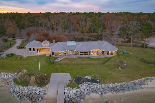 A large, multi-story house with a well-maintained lawn and a driveway leading to the entrance.