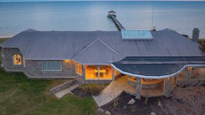 A stone house with a covered patio and a view of the sea. - Bay House by Avantstay Waterfront, Pier, Pond (Dameron)