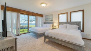 A hotel room with two beds, a TV, and a large window offering a scenic view. - Bay Cottage by Avantstay Waterfront, Pier, Pond (Dameron)