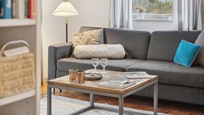 Una sala de estar acogedora con un sofá gris, una mesa de centro de madera y una lámpara de pie.