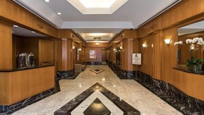 A hotel lobby with a marble floor, wooden paneling, and a central light fixture. - Walk to Central Park! Cozy 1BR w. AC, Wifi & Heating (New York)