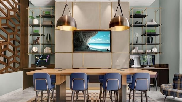 A modern kitchen with a central island, bar stools, and a large flat-screen TV. - Modern 1BR | Full Kitchen | Free WiFi  | Easy access to NYC (Jersey City)