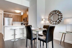 Uma cozinha moderna com ilha central, banquetas e mesa de jantar com cadeiras.