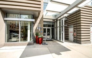 Welcome to the entrance of our building, featuring a glass entrance and a convenient door number 350, surrounded by lush potted plants.