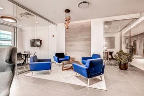 Relax in our stylish lobby with a seating area, coffee table, and lush greenery.