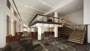 Um lobby amplo com escadaria moderna, áreas de estar confortáveis e piso estampado.