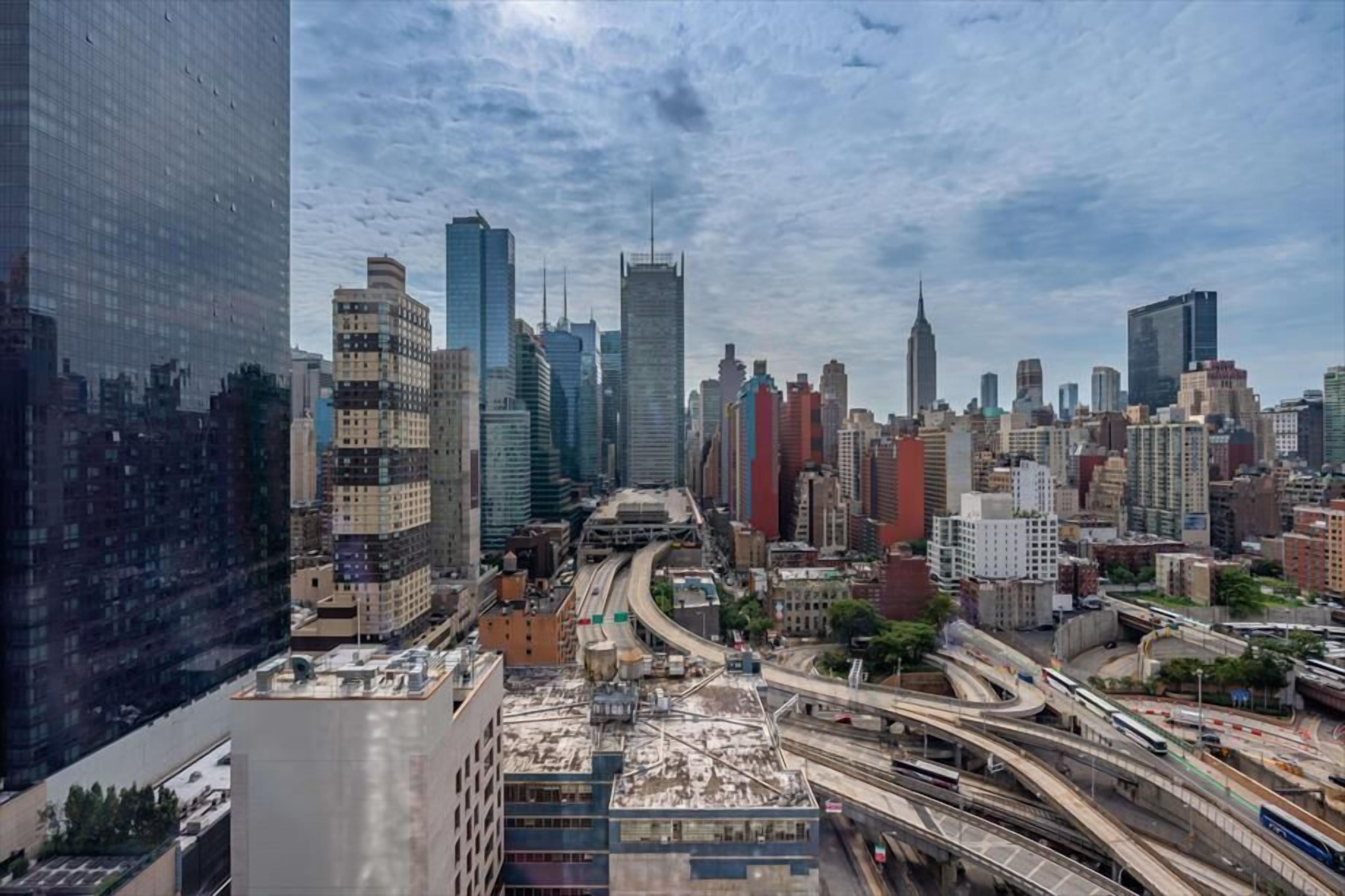Un paisaje urbano con rascacielos, una autopista y cielo despejado.