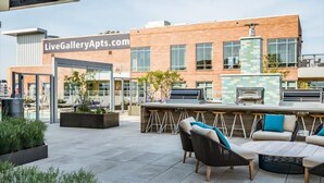 Un área de patio al aire libre con asientos y una barra, un edificio con un letrero que dice 