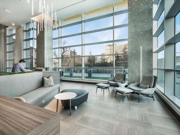 A modern interior with a large window, a sofa, a coffee table, and a chair.