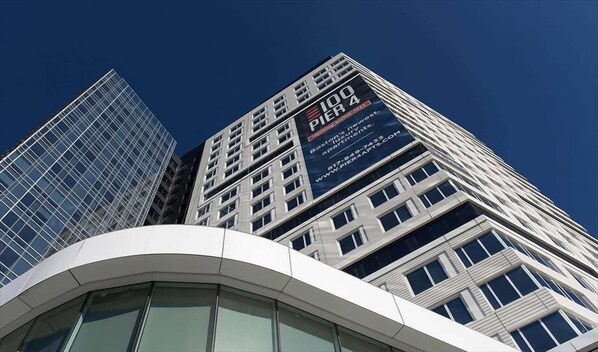 Un edificio de gran altura con un anuncio destacado de '100 Pier 4', que muestra apartamentos de lujo en Boston.
