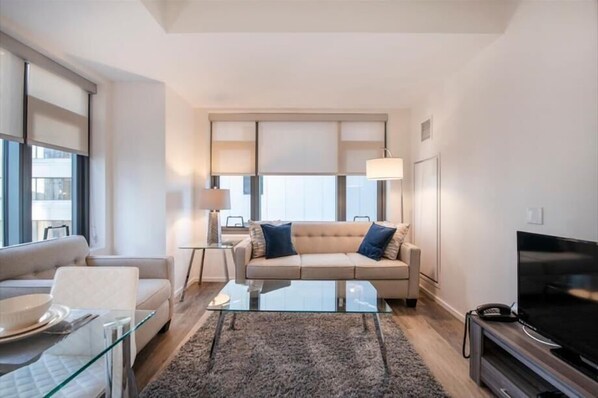 Una sala de estar moderna con sofá, mesa de centro y televisor.