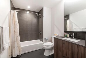 Un baño moderno con bañera, inodoro y tocador.
