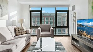 Una sala de estar moderna con un sofá, un sillón y un televisor de pantalla plana.