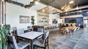 Een moderne ruimte binnenshuis met een bar, zithoekjes en decoratieve details.