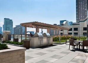 Enjoy al fresco dining on the patio, surrounded by city views and shaded by a pergola.