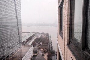 Une vue depuis une fenêtre donnant sur une rivière, avec un pont visible au loin.