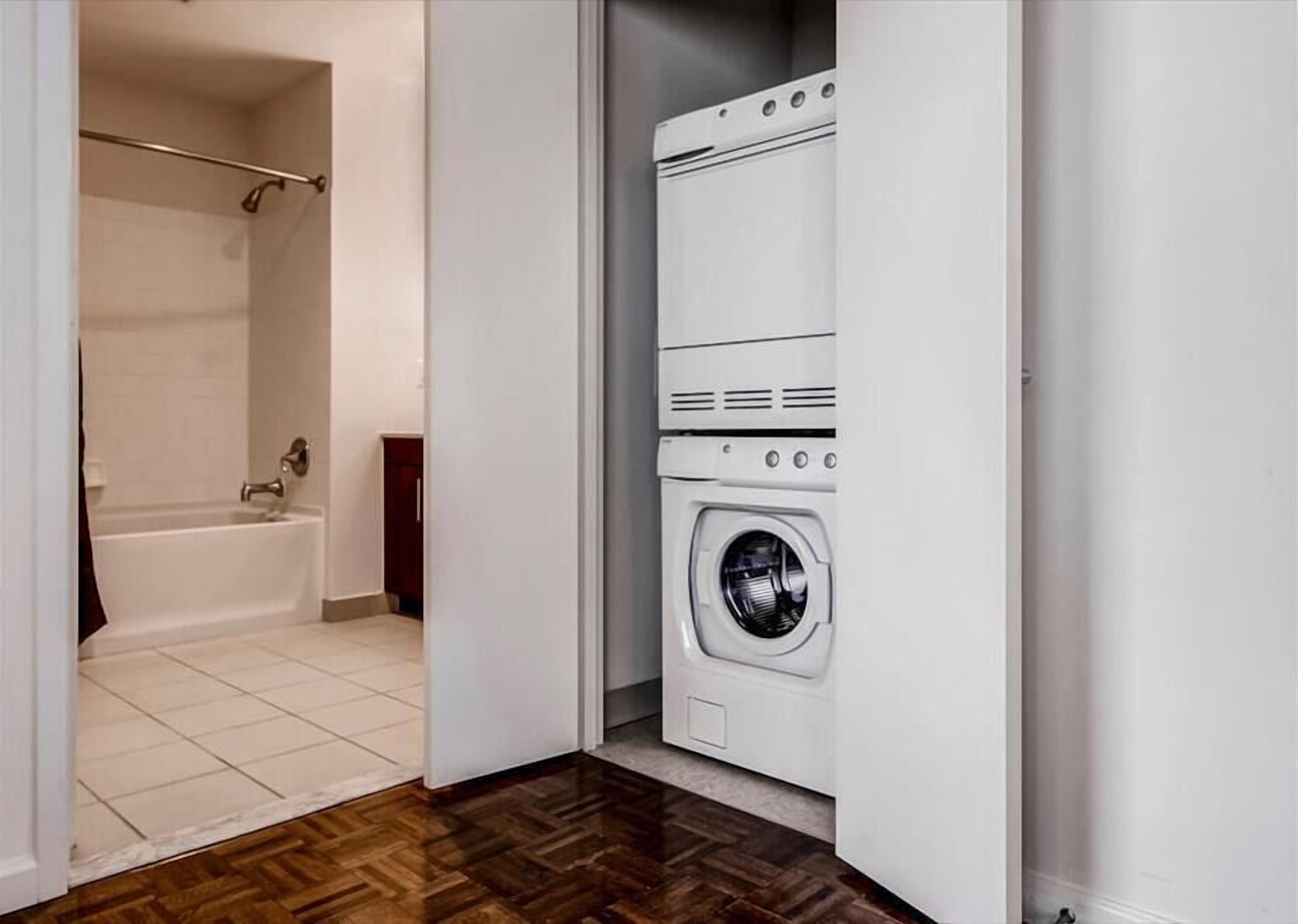 Une buanderie équipée d’un lave-linge et d’une baignoire.