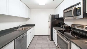 A modern kitchen with stainless steel appliances, white cabinets, and a black countertop. - Private & Clean 1BR | Work Remote | Hoboken Riverfront | Easy access to NYC (Hoboken)