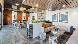 Un interior moderno con comedor, asientos y mostrador de cocina.