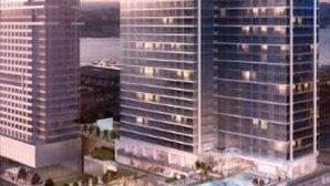 A high-rise building with a modern glass facade, multiple floors, and a rooftop pool area. - Fully Furnished 1BR | WiFi + Desk | Near Hospitals (New York)