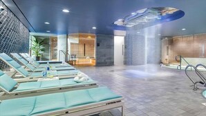 Un espace bien-être doté de fauteuils de massage, d’une piscine et d’un aménagement intérieur moderne.