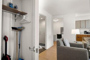 A modern hotel room with a sofa, a coffee machine, and a TV.