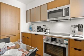 A modern kitchen with wooden cabinets, a Bosch microwave, a coffee maker, and a dishwasher.