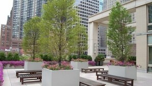 A rooftop garden with benches and planters. - Upscale 2BR | Gym + Terrace | Midtown (New York)