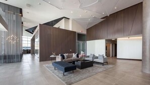 A spacious lobby with a modern design, featuring a sectional sofa, a coffee table, and a rug. - Modern 1BR | W/D | Full Kitchen | Heart of Pentagon City | GLS (Arlington)